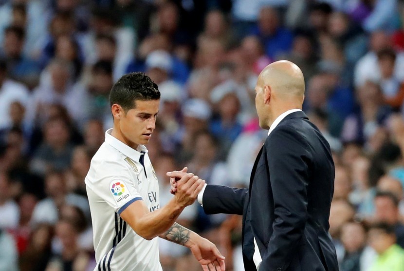 Gelandang serang Real Madrid, James Rodriguez bersalaman dengan pelatih Zinedine Zidane.