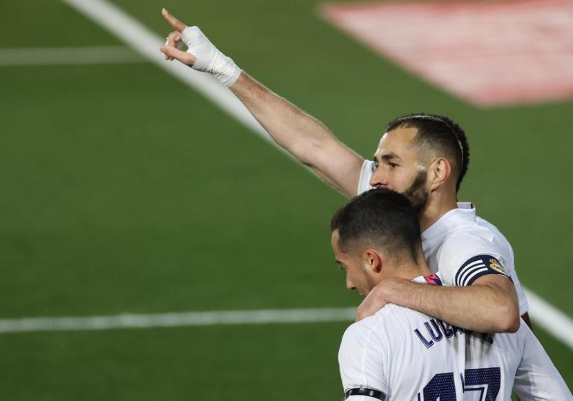 Striker Real Madrid, Karim Benzema (kanan) merayakan golnya ke gawang Barcelona pada laga El Clasico di Santiago Bernabeu, Ahad (11/4) dini hari WIB. Madrid unggul 2-0 pada babak pertama.