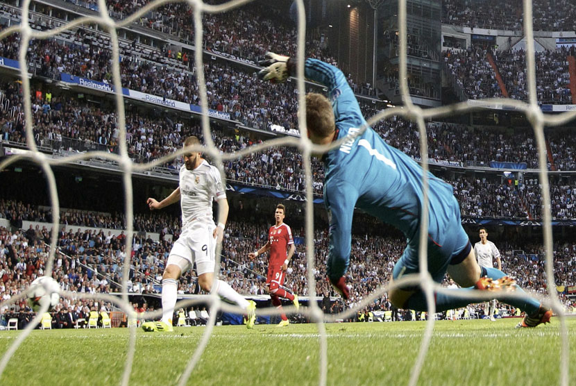 Striker Real Madrid, Karim Benzema (kiri), melepaskan tembakan membobol gawang Bayern Muenchen di leg pertama babak semifinal Liga Champions di Stadion Santiago Bernabeu, Madrid, Rabu (23/4). 