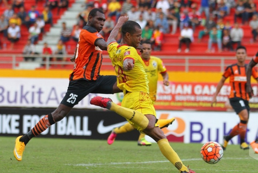 Striker Sriwijaya FC Hilton Moreira (kanan) menendang bola dijaga satu pemain Perseru Serui.