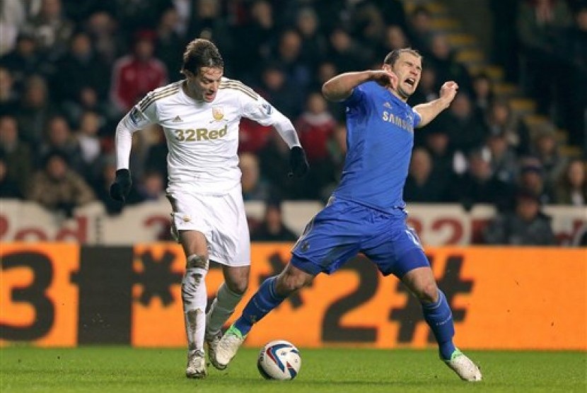 Striker Swansea Michu bertarung melawan bek Chelsea Branislav Ivanovic pada laga leg kedua Piala Liga, Kamis (24/1) dini hari.