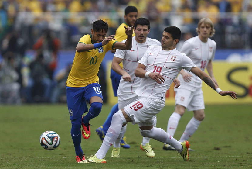 Striker Timnas Brasil, Neymar (kiri), berebut bola dengan pemain Serbia, Aleksandar Mitrovic, dalam laga uji coba di Stadion Morumbi, Sao Paulo, Jumat (6/6). 