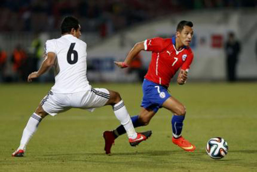 Striker timnas Cile, Alexis Sanchez (kanan), berebut bola dengan pemain timnas Mesir, Ramy Rabia, dalam laga uji coba di Santiago, Cile, Jumat (30/5). 