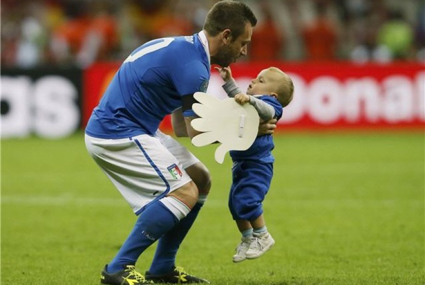 Striker timnas Italia, Antonio Cassano, menggendong anaknya usai Italia mengalahkan Jerman di babak semifinal Piala Eropa 2012. 