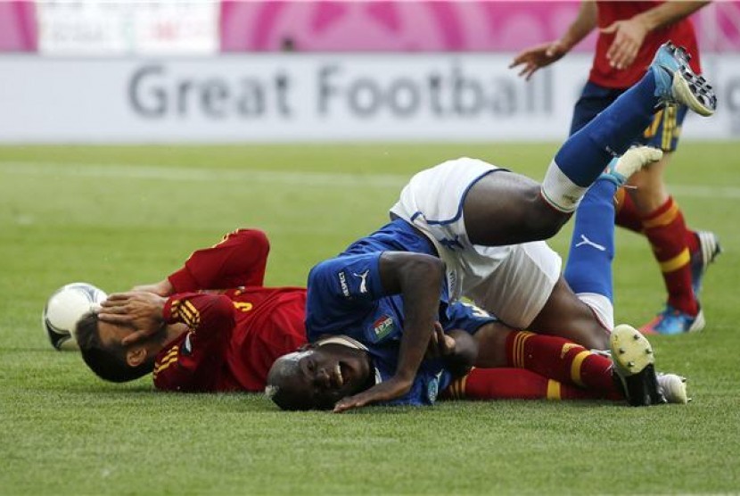 Striker timnas Italia (kanan), Mario Balotelli, terlibat adu fisik dengan bek Spanyol, Gerard Pique, di laga Grup C Piala Eropa 2012 di PGE Arena, Gdansk, Polandia, Ahad (10/6). 