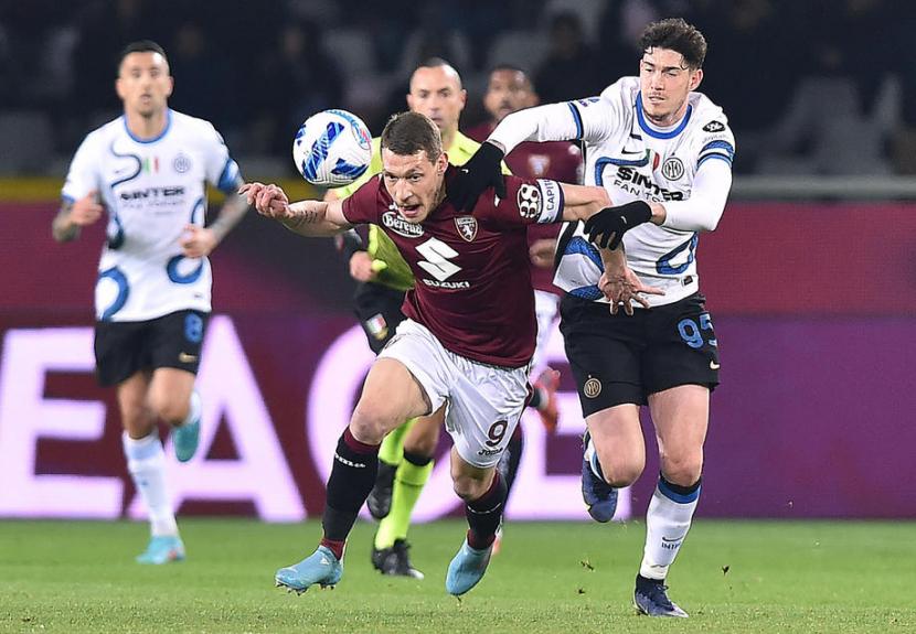 Striker Torino Torino Andrea Belotti berduel dengan pemain Inter Milan Alessandro Bastoni saat kedua tim berjumpa pada lanjutan Liga Italia Serie A 2021/2022, Senin (14/3/2022).