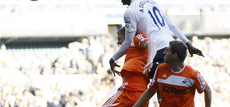 Striker Tottenham Hotspur, Emmanuel Adebayor (tengah), melepaskan sundulan saat membobol gawang Swansea City di laga Liga Primer Inggris di Stadion White Hart Lane, London, Ahad (1/4). 