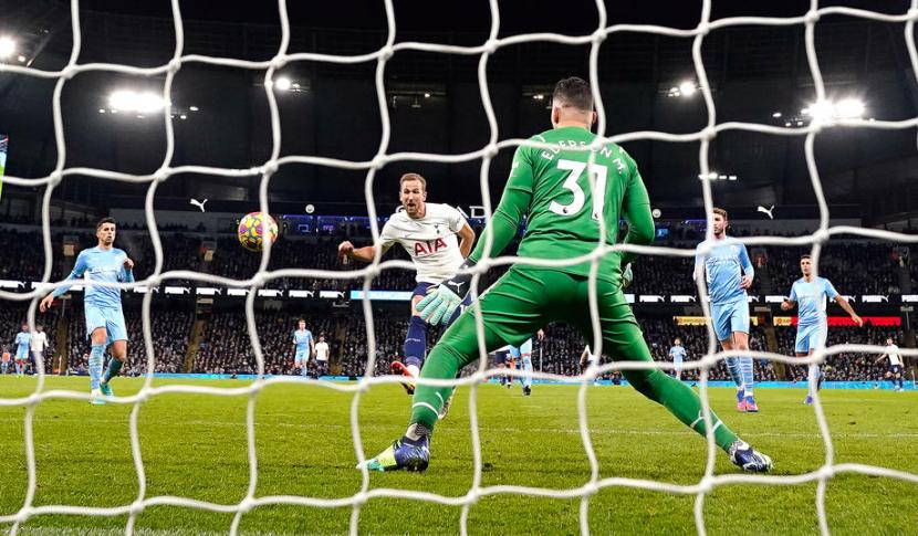Striker Tottenham Hotspur, Harry Kane (tengah) menjebol gawang Manchester City yang dikawal Ederson Moraes di Stadion Etihad, Ahad (20/2/2022) dini hari WIB. Spurs menang 3-2 atas City.