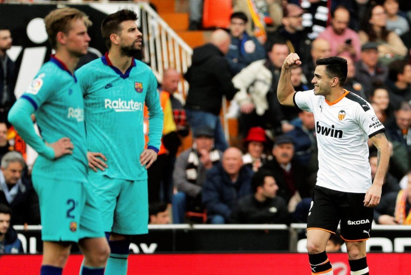 Striker Valencia, Maximiliano Gomez (kanan) merayakan gol ke gawang Barcelona pada laga La Liga di Mestalla, Sabtu (25/1). Valencia menang 2-0.