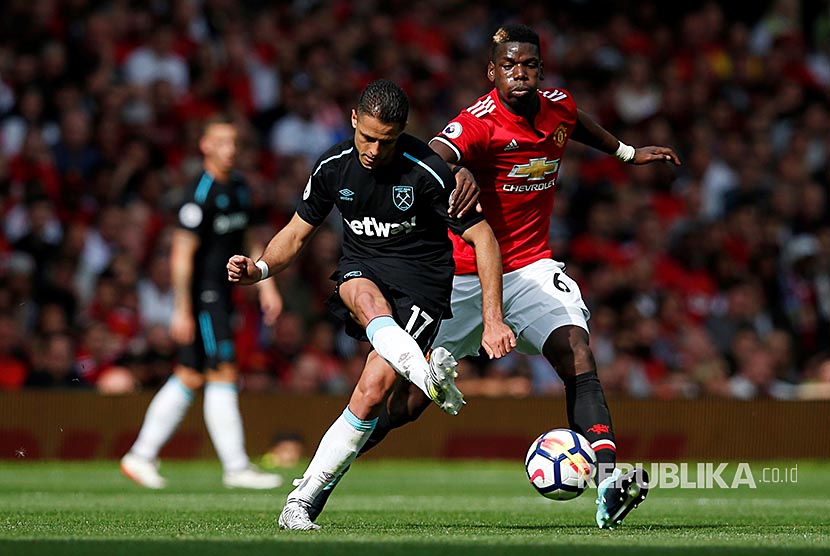 Striker Westham United Javier Hernandez dibayangi gelandang Manchester United Paul Pogba di Stadion Old Trafford, Manchester, Ahad (13/8)