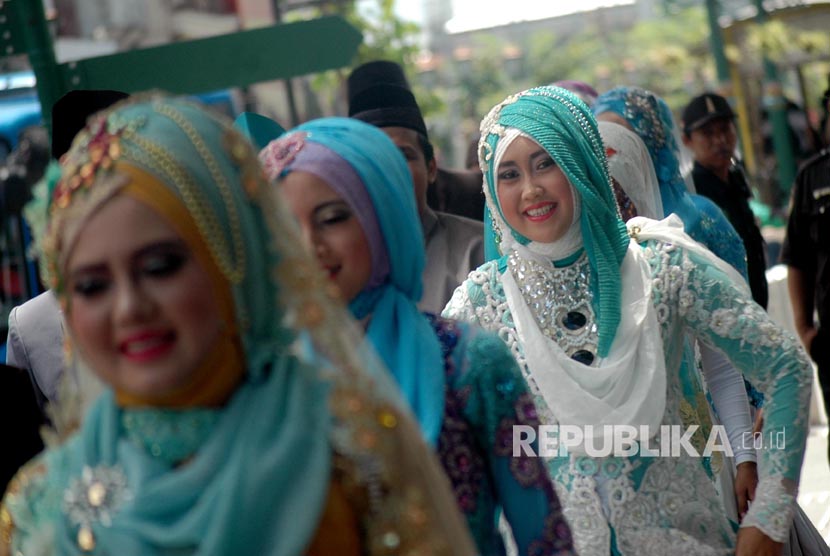 Suami dan Istri yang berperan sebagai model memperagakan busana pernikahan Muslim di Malioboro, Yogyakarta, Kamis (30/3).