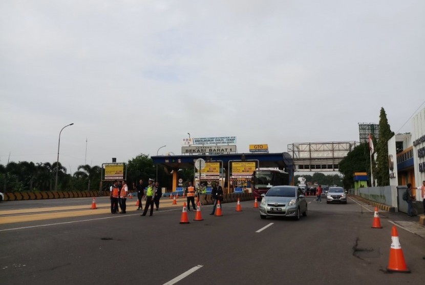 Suasana Gerbang Tol Bekasi Barat 1 saat hari pertama penerapan aturan pelat nomor ganjil-genap, Senin (12/3). Mobil berpelat ganjil dilarang masuk gerbang tol.