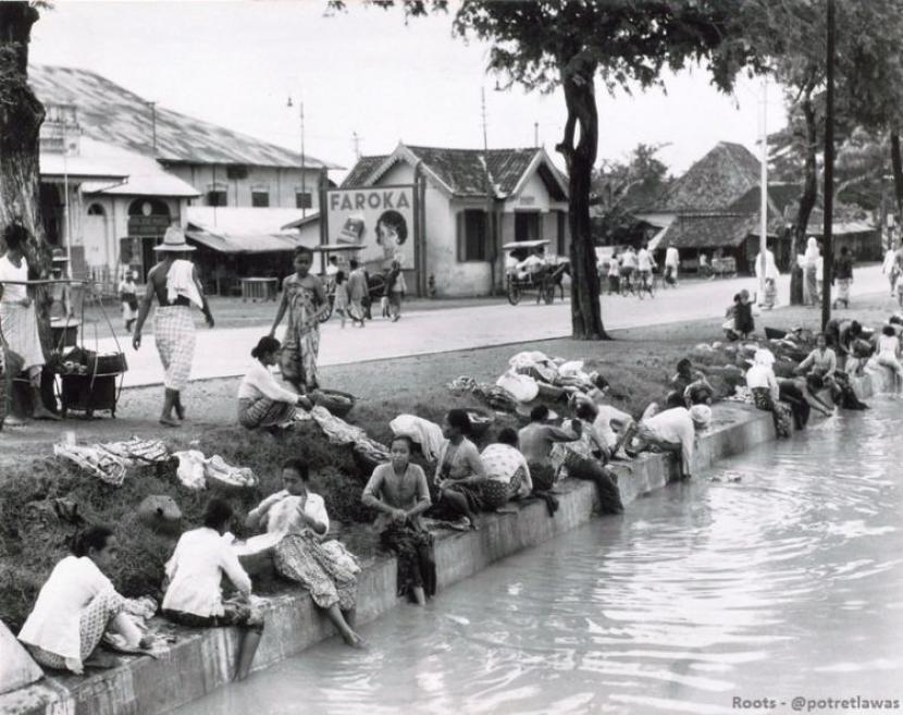 Suasana Jakarta di tahun awal Kemerdekaan. Ibu-ibu ramai mandi dan cuci di pinger kali.