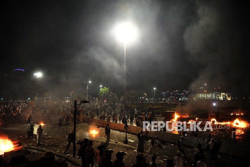 Suasana kendaraan polisi yang dibakar oleh massa saat melakukan aksi di depan istana negara, Jakarta, Jumat (4/11) malam. 