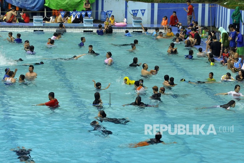 Suasana keramaian pengunjung saat berenang di kolam renang Karang Setra, Jalan Sirnagalih, Kota Bandung, Selasa (27/6). Berwisata air masih menjadi tempat liburan favorit bagi pengunjung dari dalam kota maupun luar kota untuk mengisi liburan seusai lebaran.