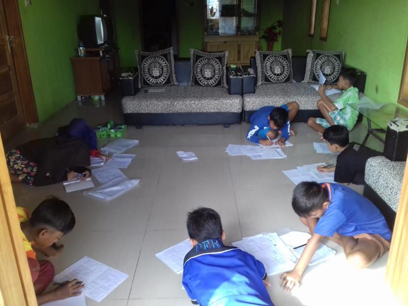 Suasana para siswa SDN Purbayani 1  belajar di rumah, di Desa Purbayani, Kecamatan Caringin, Kabupaten Garut. Salah seorang guru SDN Purbayani 1 mesti mendatangi rumah siswanya agar proses belajar di rumah berjalan maksimal. I