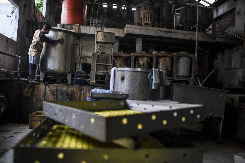 Pekerja membersihkan peralatan saat menggelar aksi mogok berproduksi di salah satu pabrik tahu di Jakarta.