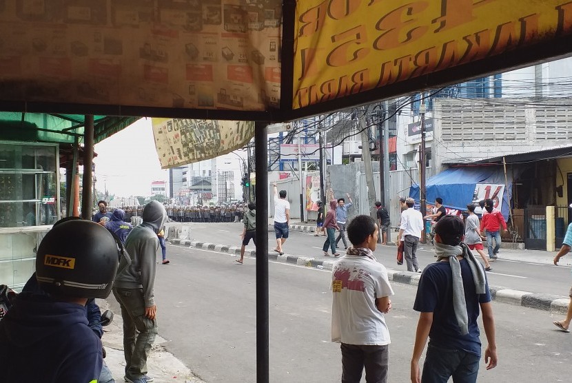 Suasana sebelum massa melempari pagar betis yang dibuat polisi di Jl Brigjen Katamso, Slipi, Jakarta Barat, Rabu (22/5) sore WIB.