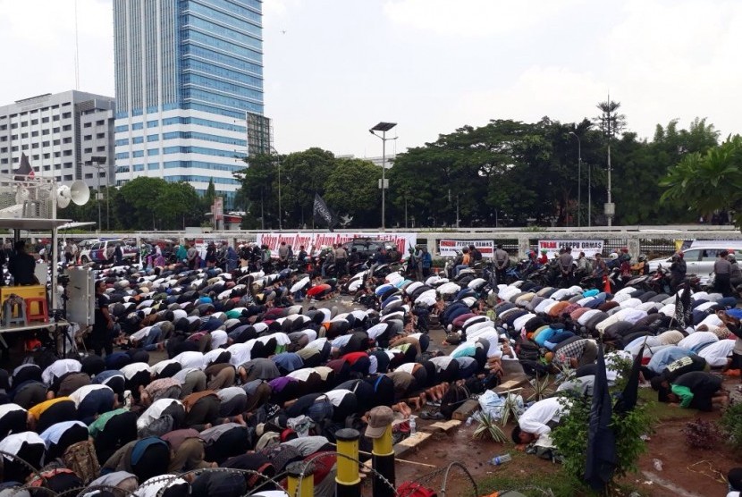 Suasana shalat zuhur berjamaah massa aksi tolak Perppu Ormas di depan Gedung DPR RI, Selasa (24/10).