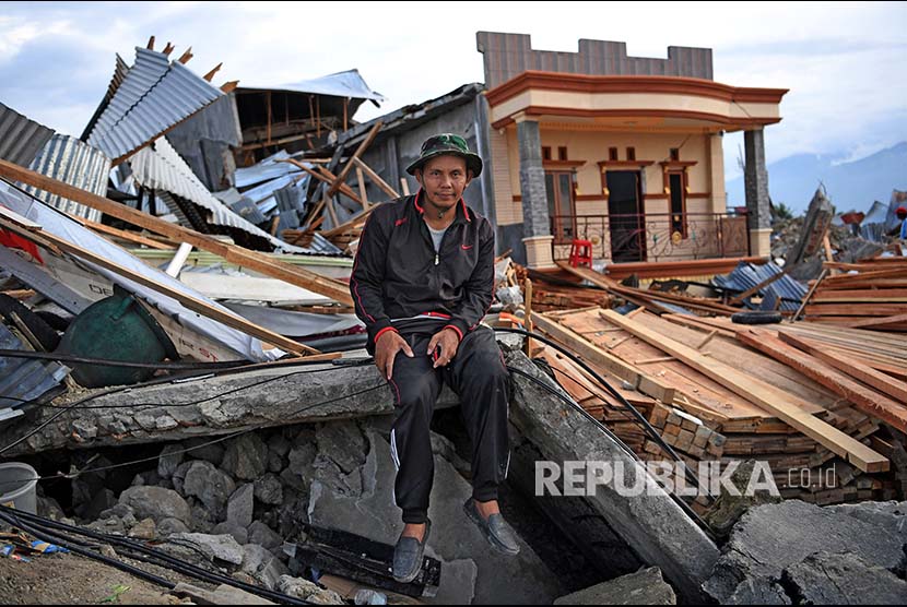 Subhan Bachong berpose di depan rumahnya yang rusak akibat likuifkasi di Petobo, Palu, Sulawesi Tengah.