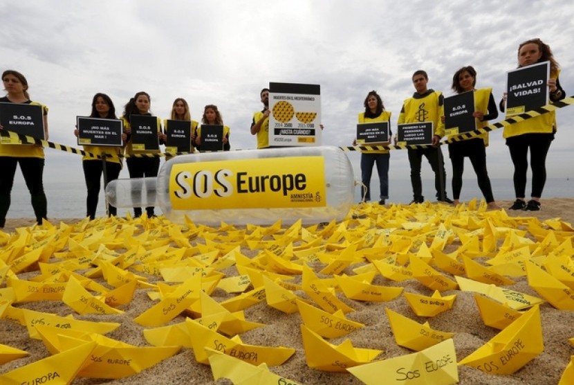 Sukarelawan dari Amnesty International melakukan aksi meletakkan kapal kertas di sebuah pantai di Barcelona, Spanyol. Kapal yang diberi tulisan SOS Europe itu merupakan keprihatinan dari banyak imigran yang meninggal di kapal saat hendak masuk ke Eropa.