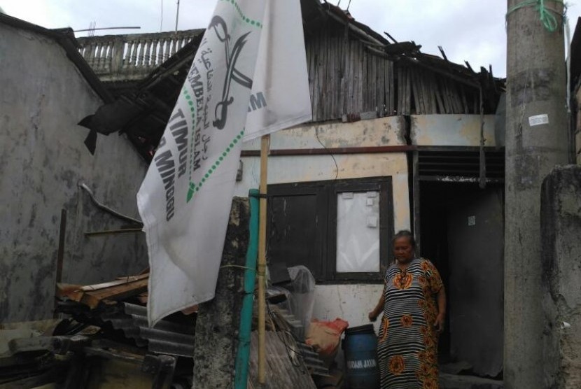 Sunarni (50) berdiri di depan rumahnya di Pejaten Timur, Jakarta Selatan, Senin (3/4) lalu. 