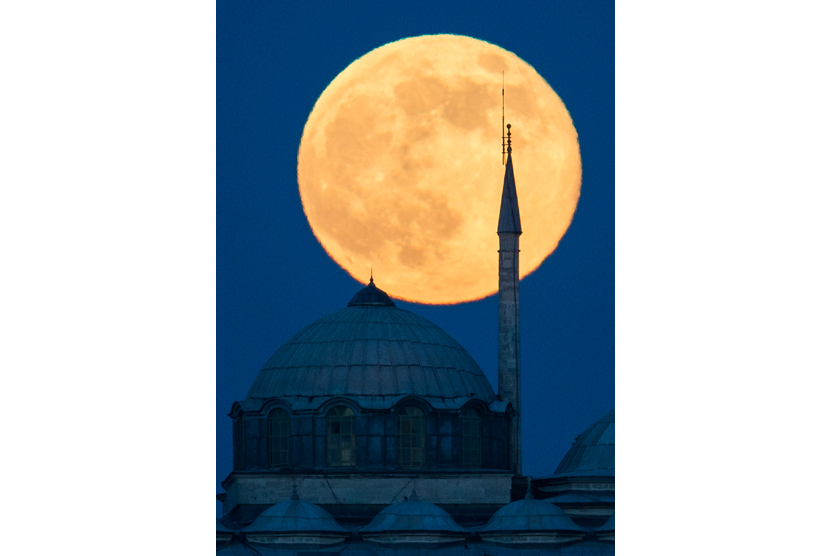  Supermoon tampak di belakang bangunan Istana Topkapi di Istanbul, Turki, Ahad (23/6).   (AP/Gero Breloer)