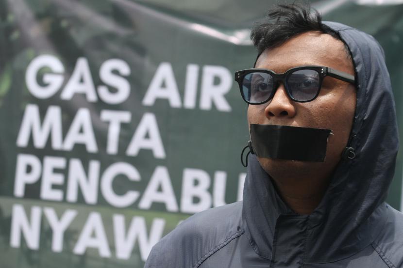 Suporter Arema FC (Aremania) menutup mulutnya dengan lakban saat berunjuk rasa di depan Balaikota Malang, Jawa Timur, Kamis (20/10/2022). Mereka menuntut penegakan hukum yang adil, terbuka dan tak pandang bulu dalam kasus tragedi Kanjuruhan yang menelan 133 korban jiwa. 