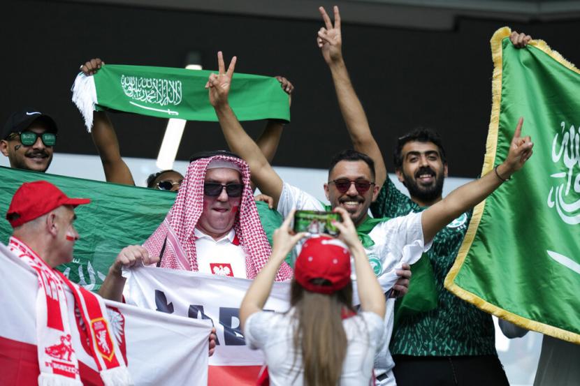 Ilustrasi warga Qatar dan Saudi bersorak menyaksikan pertandingan sepak bola.