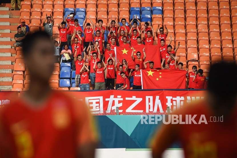Suporter China menyaksikan babak penyisihan cabang olahraga sepak bola.