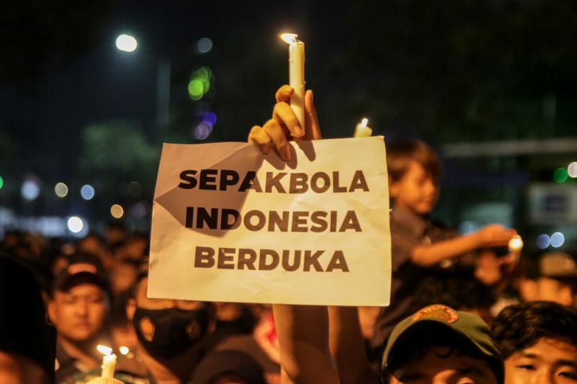 Suporter Delta Sidoarjo memegang lilin saat mengikuti doa bersama di Gelora Delta Sidoarjo, Jawa Timur, Selasa (4/10/2022). Doa bersama itu untuk para korban tragedi Kanjuruhan, Malang. 