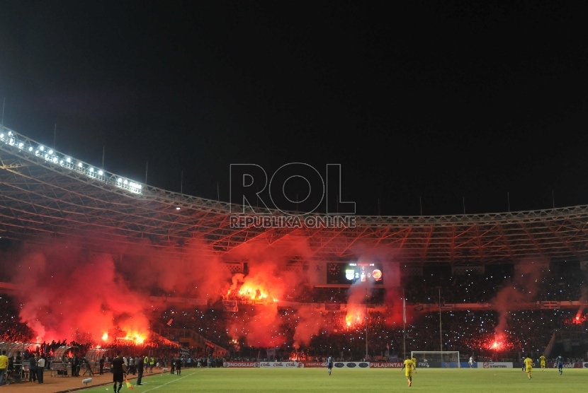 [foto ilustrasi] Suporter menyalakan flare di dalam stadion Gelora Bung Karno.