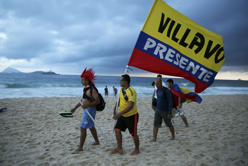 Suporter Kolombia berjalan di pantai Ipanema.