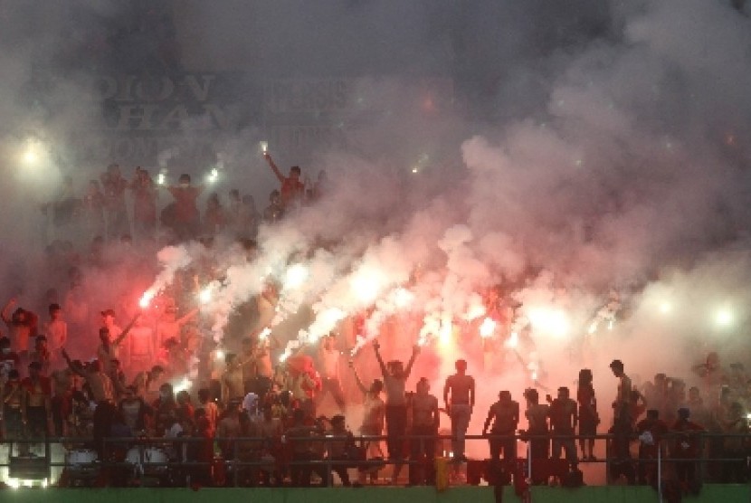 Suporter membakar kembang api di laga Persis Solo kontra Lion XII asal Singapura di Stadion Manahan, Solo, Sabtu (4/1).