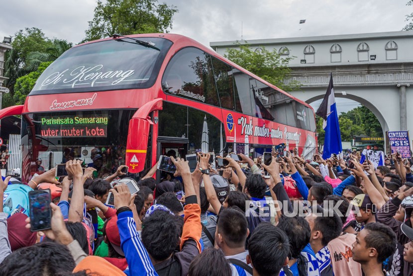 Suporter menyambut kedatangan bus rombongan Tim PSIS Semarang saat konvoi perayaan lolosnya tim sepak bola tersebut ke Liga 1, di Semarang, Jawa Tengah, Kamis (30/11).