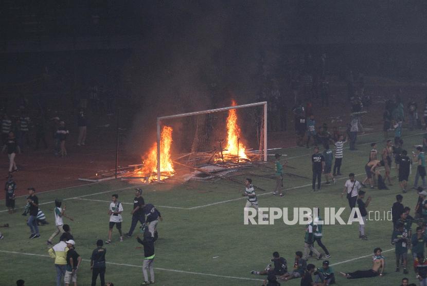 Suporter Persebaya membakar papan sponsor usai pertandingan Liga 1 2019 antara Persebaya dan PSS Sleman di Stadion Gelora Bung Tomo, Surabaya, Jawa Timur, Selasa (29/10). Kericuhan tersebut terjadi karena kekecewaan para suporter Persebaya usai timnya kalah 2-3 atas PSS Sleman. 