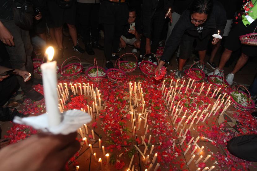 Suporter Persebaya memegang lilin saat mengikuti doa bersama di Tugu Pahlawan, Surabaya, Jawa Timur, Senin (3/10/2022). Soal tragedi Kanjuruhan, pengamat menilai seharusnya peran Nugroho dimaksimalkan.