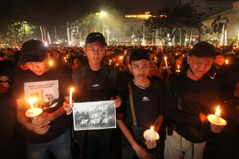 Suporter Persebaya memegang lilin saat mengikuti doa bersama di Tugu Pahlawan, Surabaya, Jawa Timur, Senin (3/10/2022). Doa bersama itu untuk para korban tragedi kerusuhan di Stadion Kanjuruhan, Malang. 