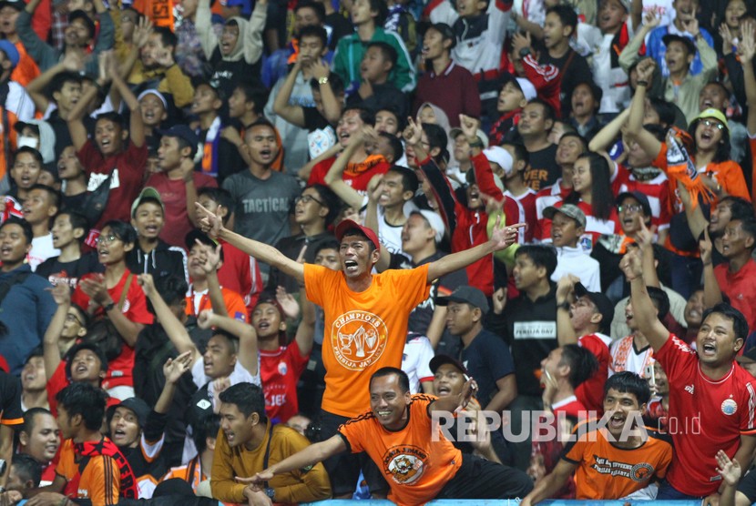 Suporter Persija Jakarta, Jakmania, bersorak saat mengetahui tim kesayangannya mengalahkan Arema FC dalam pertandingan perebutan juara Grup B Piala Gubernur Jatim di Stadion Kanjuruhan, Malang, Jawa Timur, Sabtu (15/2). Persija melaju ke babak semifinal untuk menantang Madura United.