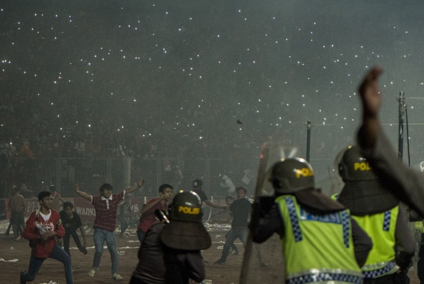   Suporter Persija Jakarta (Jakmania) melempari petugas kepolisian saat pertandingan Persija melawan Sriwijaya FC pada ajang Torabika Soccer Championship di Stadion Utama Gelora Bung Karno, Jakarta, Jumat (24/6).