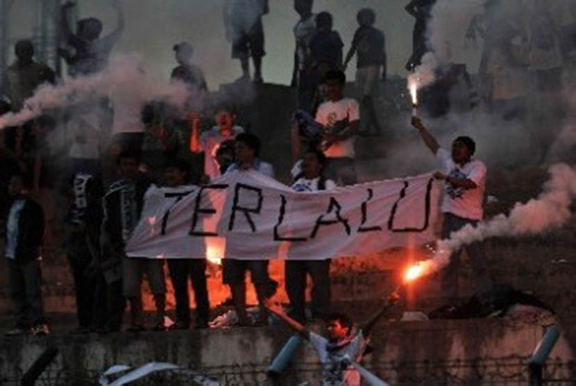 Suporter salah satu kesebelasan membentangkan spanduk dan menyalakan kembang api dalam laga lanjutan Liga Primer Indonesia antara Tangerang Wolves lawan Jakarta FC di Stadion Benteng, Tangerang, Banten. 