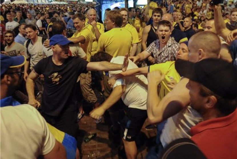 Suporter timnas Inggris dan pendukung Swedia terlibat bentrok di Zona Fans di Kiev, Ukraina, pada Kamis (14/6). 