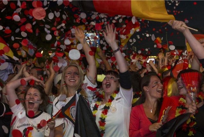 Suporter timnas Jerman merayakan kemenangan timnas Jerman usai menekuk Denmark di laga terakhir Grup B Piala Eropa 2012 di Fan Mile, Berlin, Jerman, pada Ahad (17/6). 