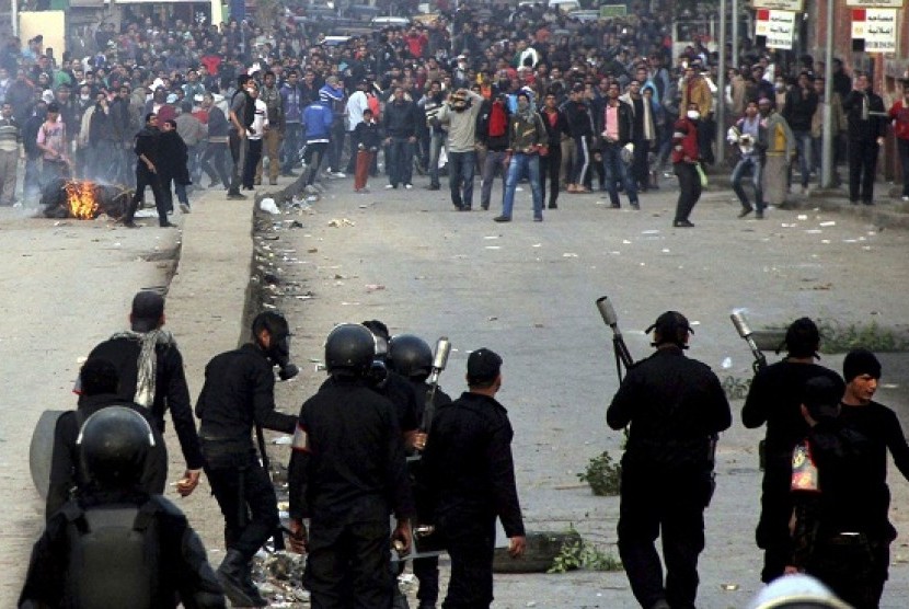 Supporters of the Muslim Brotherhood and ousted Egyptian President Mohamed Mursi run after riot police fired tear gas during clashes in Cairo December 20, 2013. 