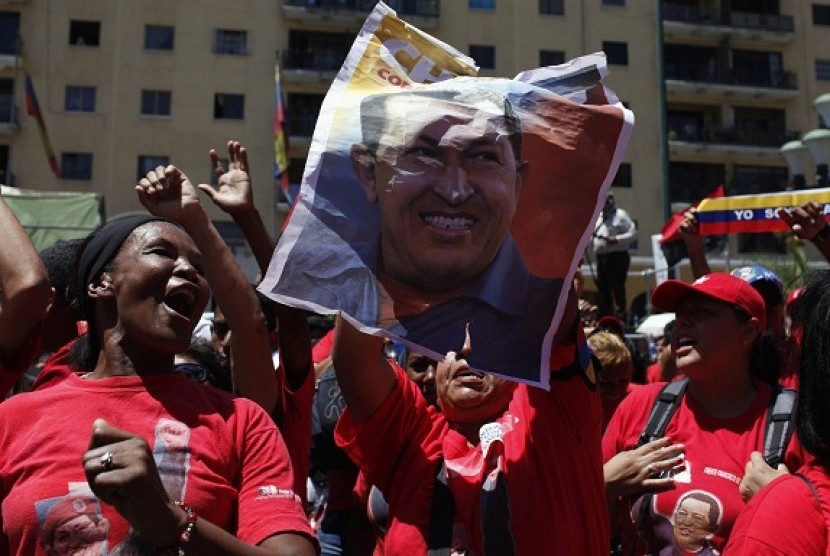 Supporters of Venezuela's President Hugo Chavez hold a picture of him as they attend a rally in Caracas March 3, 2013.