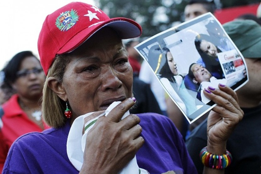 Supporters of Venezuela's President Hugo Chavez react to the announcement of his death outside the hospital where he was being treated, in Caracas, March 5, 2013. 