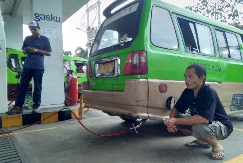 Suryadi, seorang sopir angkot di Bogor sedang menunggu pengisian bahan bakar gas untuk angkotnya di SPBG PGN Bogor, Bogor Tengah, awal Desember lalu. Sejak satu tahun terakhir, Suryadi dan banyak sopir angkot lainnya beralih menggunakan bahan bakar gas PGN. Alasannya, harga bahan bakar yang lebih murah bisa memangkas operasional mereka.