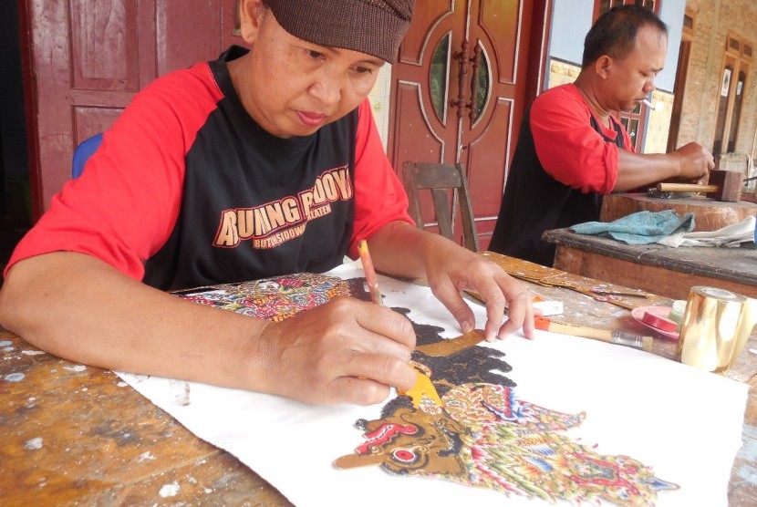 Sutarmi sedang memulas wayang kulit tokoh Rajamala di Sanggar Aruming Budoyo, Dukuh Butuh, Desa Sidowarno, Kabupaten Klaten, Jawa Tengah, Rabu (25/12).