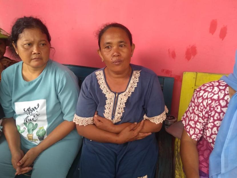 Sutiah (kedua dari kiri), seorang warga Desa Eretan Kulon, Kecamatan Kandanghaur, Kabupaten Indramayu yang rumahnya ambruk akibat dihempas gelombang tinggi, saat ditemui di lokasi pengungsian Balai Desa Kertawinangun, Ahad (1/1/2023). 