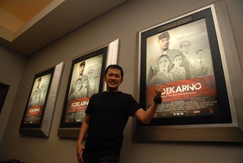 Sutradara film Hanung Bramantyo berfoto didepan jajaran poster pada gala premiere film karyanya berjudul 